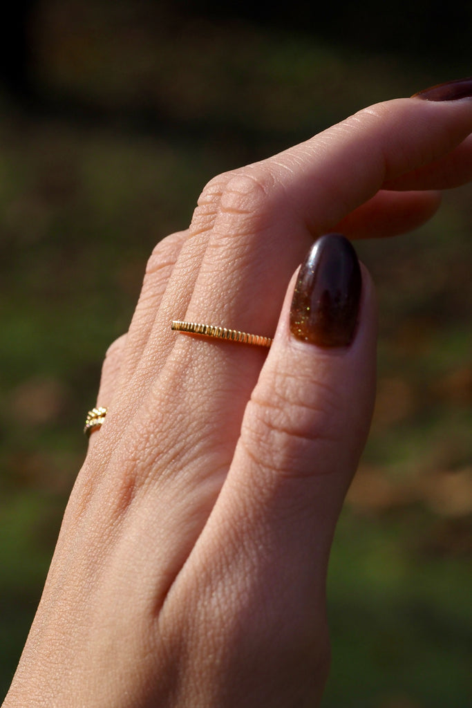 ジュエリースタジオMASHIROのアップサイクルジュエリー。イエローゴールドの木目デザインリングの着用画像。