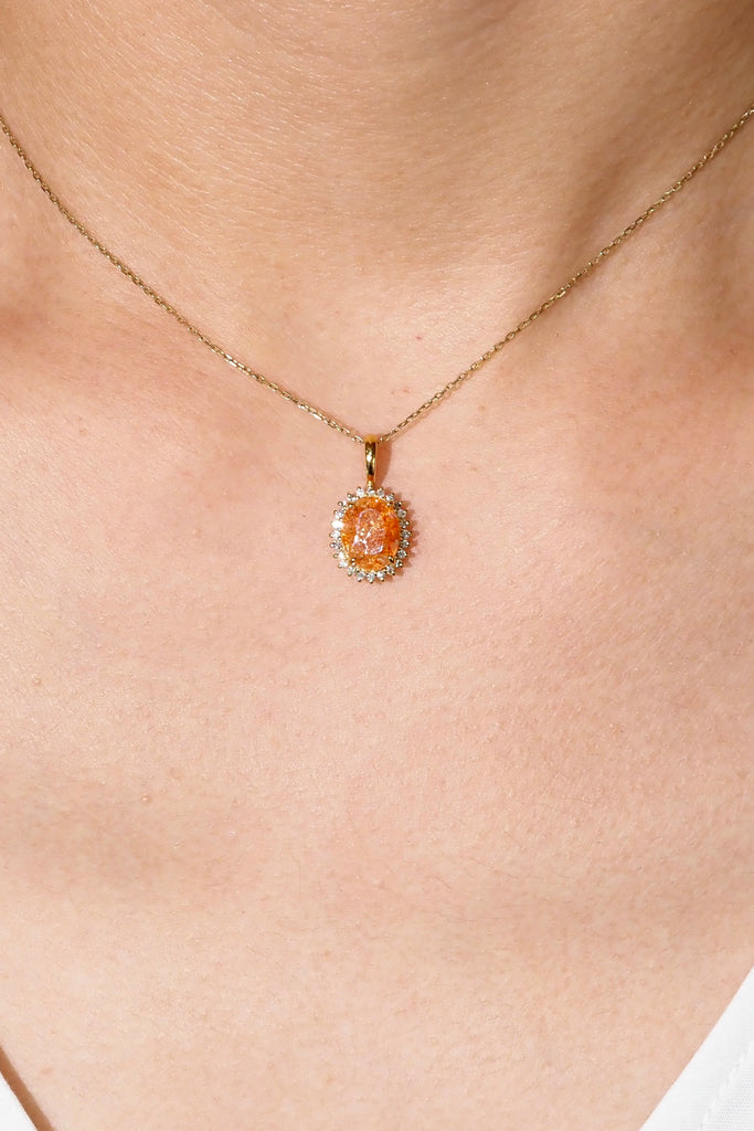 ジュエリースタジオMASHIROのアップサイクルカラーストーンジュエリー。イリュージョンサンストーン・オーバルカットのダイヤ取り巻きチャーム（ペンダントトップ）。イエローゴールド