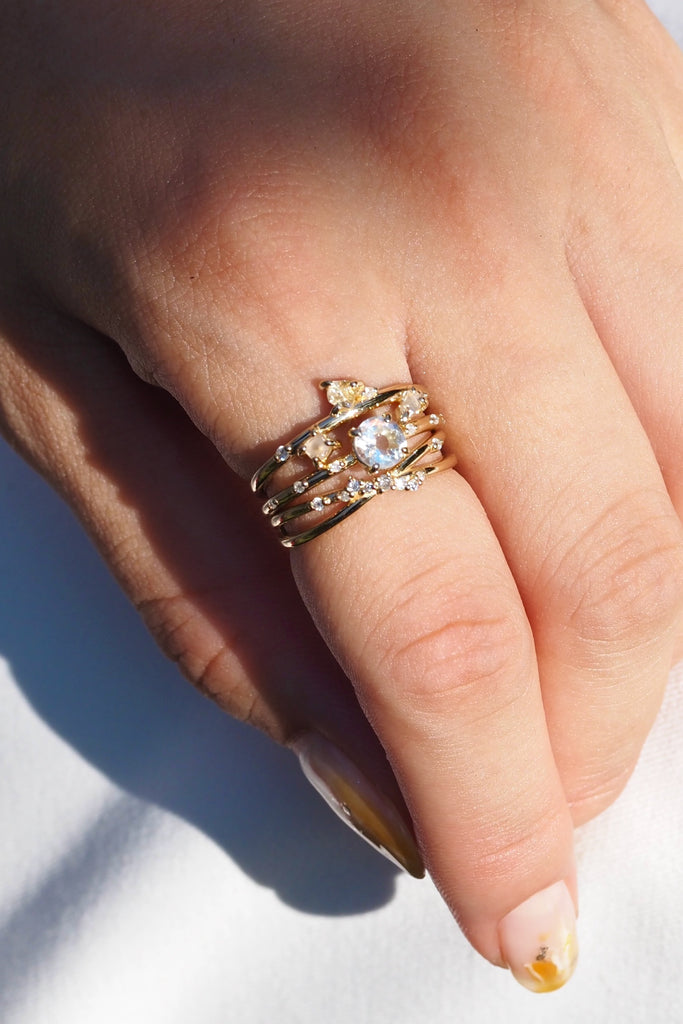 ジュエリースタジオMASHIROのカラーストーンアップサイクルジュエリー。レインボームーンストーン、天然ダイヤモンド、ダイヤモンド原石をセットしたシャンパンゴールドの重ね付けリング３本セット。