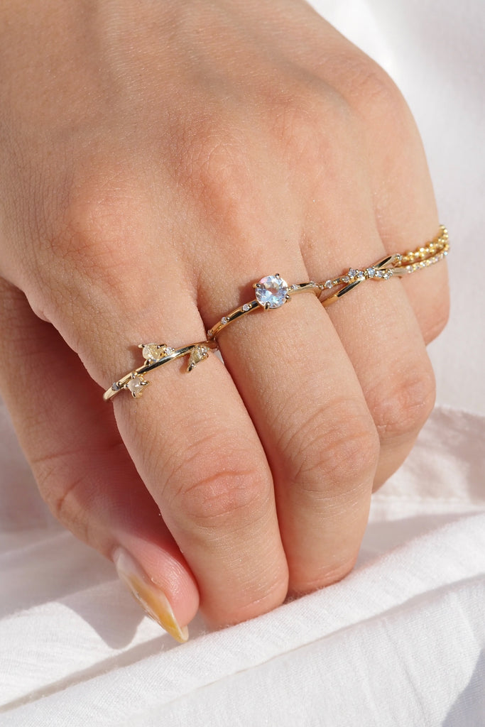 ジュエリースタジオMASHIROのカラーストーンアップサイクルジュエリー。レインボームーンストーン、天然ダイヤモンド、ダイヤモンド原石をセットしたシャンパンゴールドの重ね付けリング３本セット。