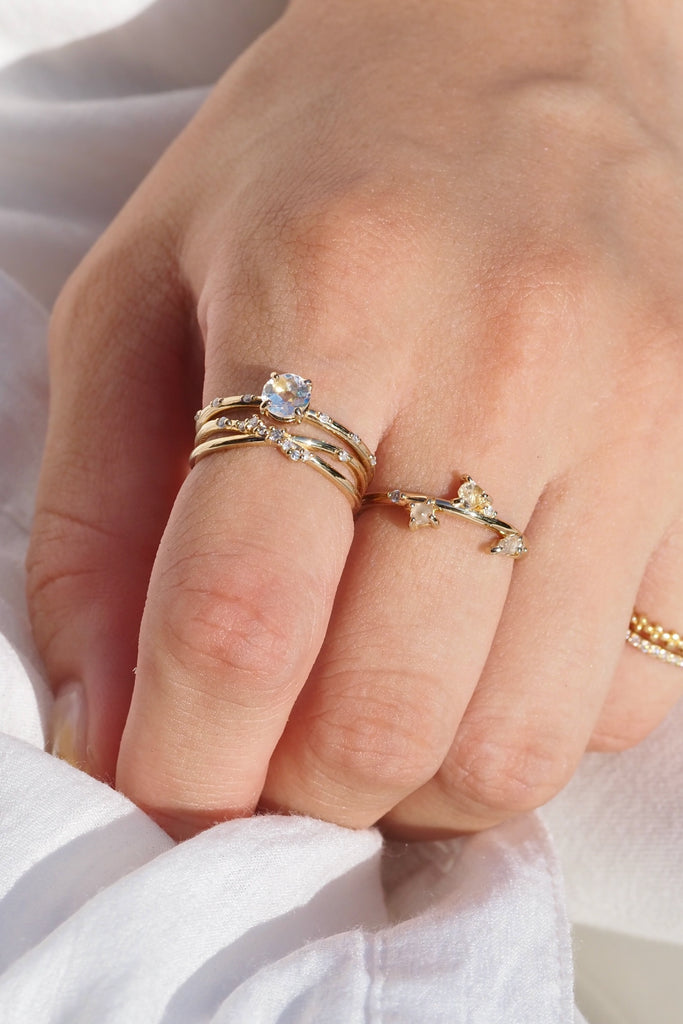 ジュエリースタジオMASHIROのカラーストーンアップサイクルジュエリー。レインボームーンストーン、天然ダイヤモンド、ダイヤモンド原石をセットしたシャンパンゴールドの重ね付けリング３本セット。