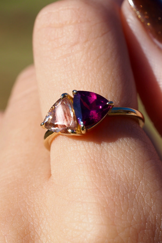 ジュエリースタジオMASHIROのアップサイクルジュエリー。オレゴンサンストーン・トリリアントカット・約1.07ct・約6.8*6.6mm・アメリカオレゴン州産｜ロードライトガーネット・トリリアント・約1.17ct・約7mm・インド産。シャンパンゴールドカラーのコンビリングの着用画像