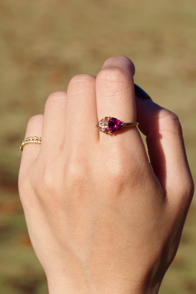 ジュエリースタジオMASHIROのアップサイクルジュエリー。オレゴンサンストーン・トリリアントカット・約1.07ct・約6.8*6.6mm・アメリカオレゴン州産｜ロードライトガーネット・トリリアント・約1.17ct・約7mm・インド産。シャンパンゴールドカラーのコンビリングの着用画像。