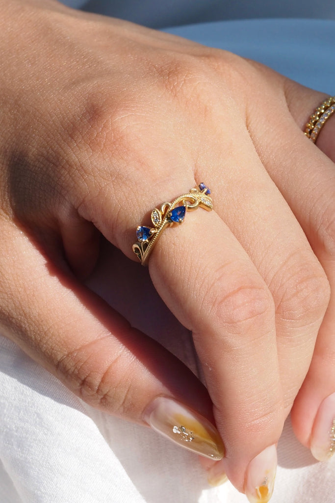 ジュエリースタジオMASHIROのカラーストーンアップサイクルジュエリー。アラベスク（唐草）デザインの、ブルーサファイアとダイヤモンドをセットしたウェーブミルグレインリング。シャンパンゴールドマット。