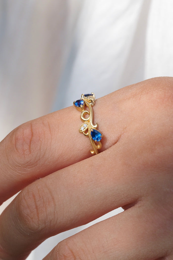 ジュエリースタジオMASHIROのカラーストーンアップサイクルジュエリー。アラベスク（唐草）デザインの、ブルーサファイアとダイヤモンドをセットしたウェーブミルグレインリング。シャンパンゴールドマット。