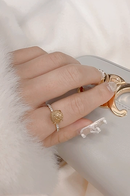 MASHIRO ERINKOがゴールドルチルクォーツを使ったハーフエタニティ・爪留のリングをつけている写真