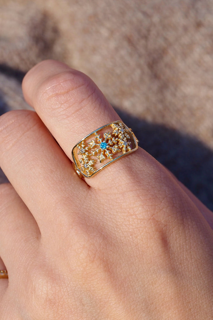 ジュエリースタジオMASHIROのアップサイクルジュエリー。アイスブルーダイヤモンド・ラウンド・av 0.03ct・av 2mm・ダイヤモンド（４石）・av 0.02ct・av 1.2mm。シャンパンゴールドの雪の結晶レースリングの着用画像。