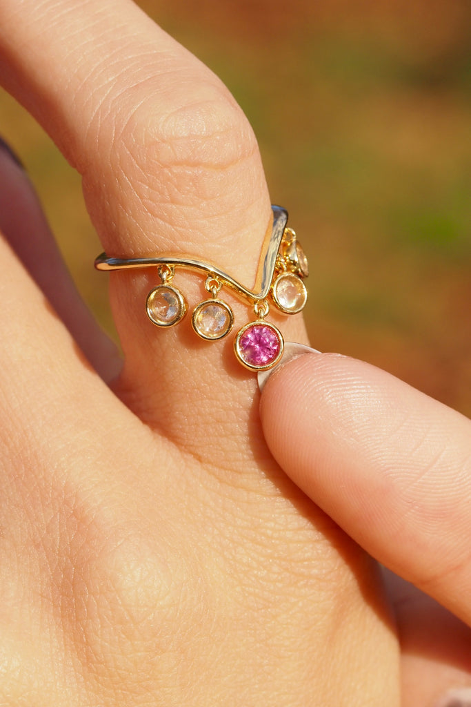ジュエリースタジオMASHIROのアップサイクルジュエリー。レインボームーンストーン（４石）・ラウンド・合計：約0.36ct・約3mm｜ピンクサファイア・ラウンド・約0.29ct・約3.8mm。シャンパンゴールドカラーのシャンデリアリングの着用画像。