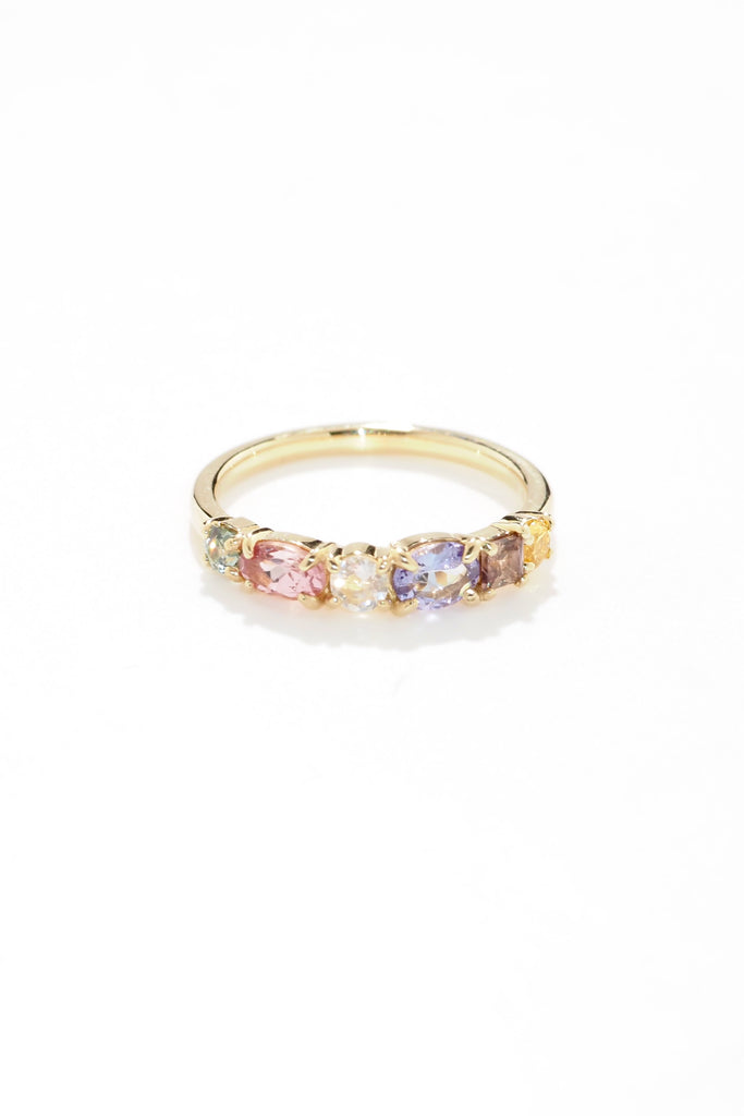 ジュエリースタジオMASHIROのアップサイクルジュエリー。マラヤガーネット・オーバル・約0.3ct・約 5*3mm・タンザニア産｜タンザナイト・オーバルカット・約0.28ct・約4.9*3.8mm｜レインボーームーンストーン・ラウンド・約0.09ct・約3mm｜マルチカラーサファイア（３石：ラウンド・プリンセス・ヘキサゴン）・合計：0.34ct・約2.6mm。シャンパンゴールドカラーのカクテルエタニティリング。