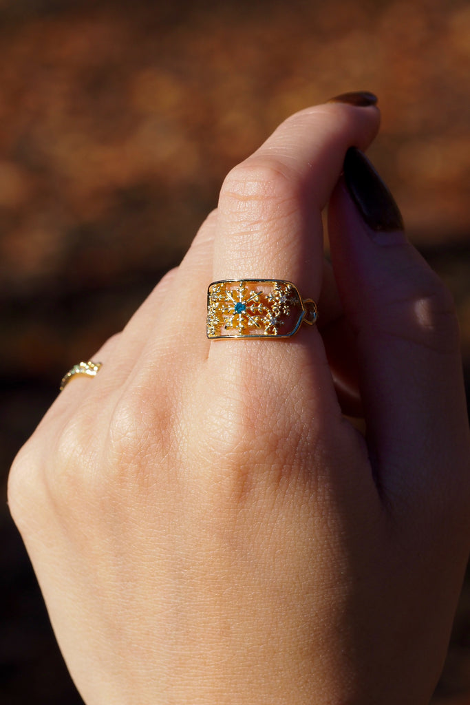 ジュエリースタジオMASHIROのアップサイクルジュエリー。アイスブルーダイヤモンド・ラウンド・av 0.03ct・av 2mm・ダイヤモンド（４石）・av 0.02ct・av 1.2mm。シャンパンゴールドの雪の結晶レースリングの着用画像。