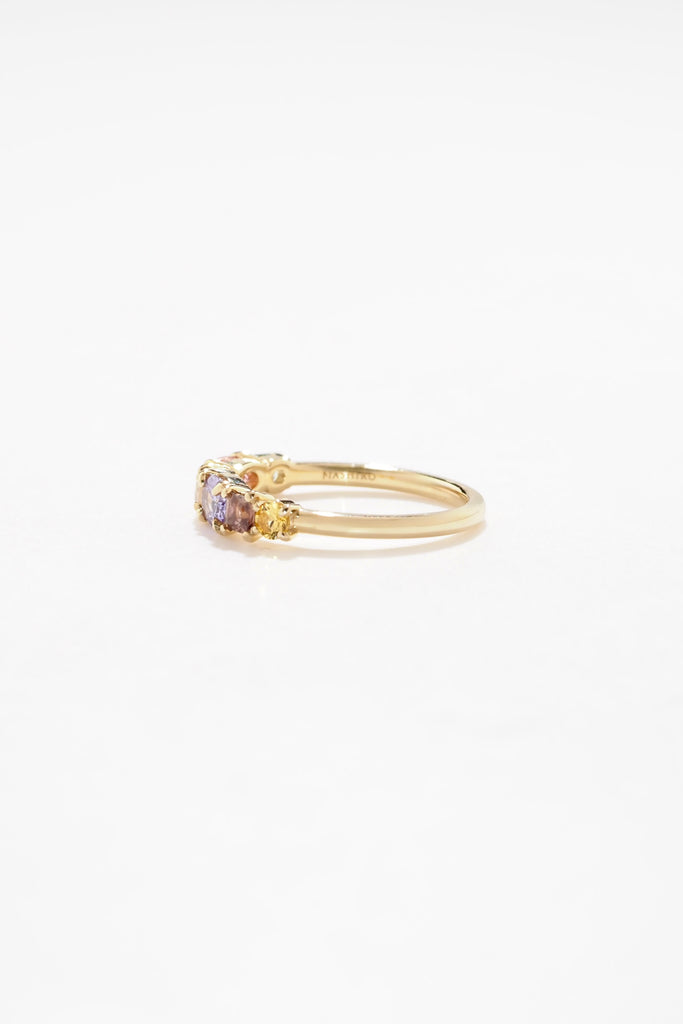 ジュエリースタジオMASHIROのアップサイクルジュエリー。マラヤガーネット・オーバル・約0.3ct・約 5*3mm・タンザニア産｜タンザナイト・オーバルカット・約0.28ct・約4.9*3.8mm｜レインボーームーンストーン・ラウンド・約0.09ct・約3mm｜マルチカラーサファイア（３石：ラウンド・プリンセス・ヘキサゴン）・合計：0.34ct・約2.6mm。シャンパンゴールドカラーのカクテルエタニティリング。