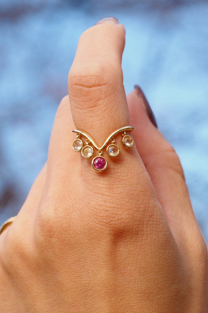 ジュエリースタジオMASHIROのアップサイクルジュエリー。レインボームーンストーン（４石）・ラウンド・合計：約0.36ct・約3mm｜ピンクサファイア・ラウンド・約0.29ct・約3.8mm。シャンパンゴールドカラーのシャンデリアリングの着用画像。