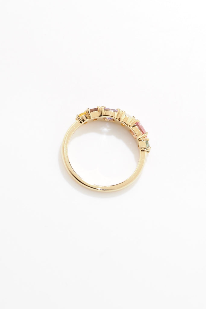 ジュエリースタジオMASHIROのアップサイクルジュエリー。マラヤガーネット・オーバル・約0.3ct・約 5*3mm・タンザニア産｜タンザナイト・オーバルカット・約0.28ct・約4.9*3.8mm｜レインボーームーンストーン・ラウンド・約0.09ct・約3mm｜マルチカラーサファイア（３石：ラウンド・プリンセス・ヘキサゴン）・合計：0.34ct・約2.6mm。シャンパンゴールドカラーのカクテルエタニティリング。