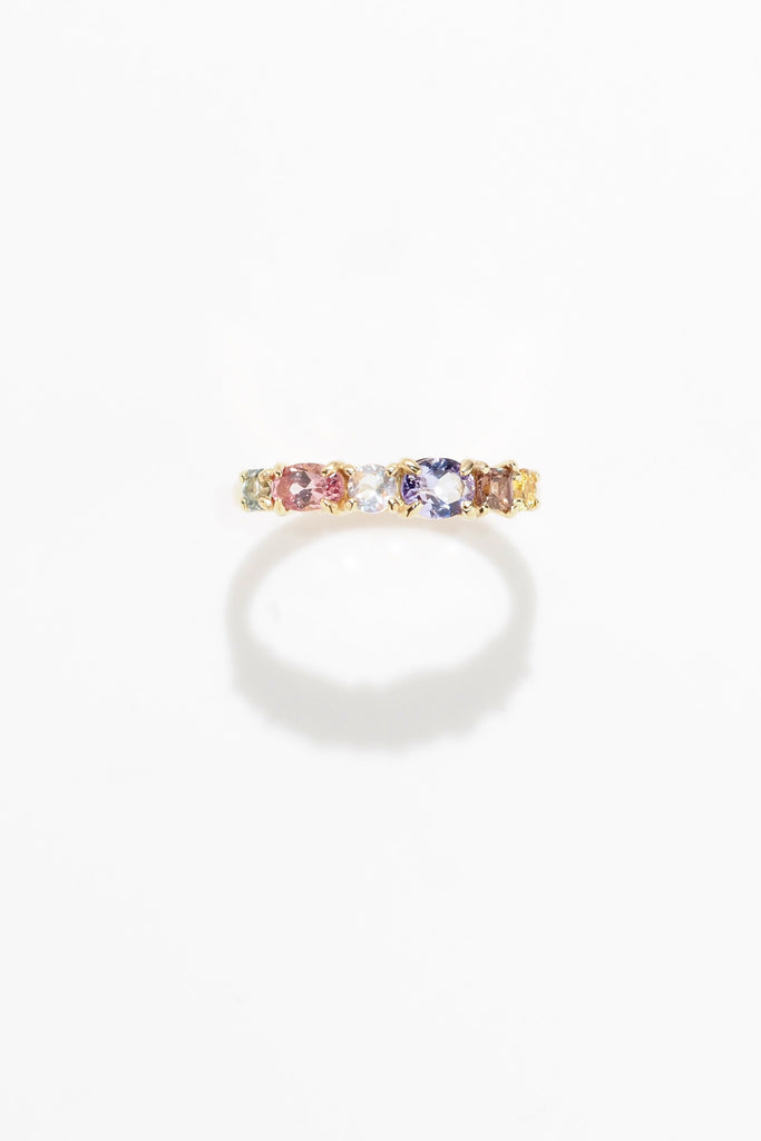 ジュエリースタジオMASHIROのアップサイクルジュエリー。マラヤガーネット・オーバル・約0.3ct・約 5*3mm・タンザニア産｜タンザナイト・オーバルカット・約0.28ct・約4.9*3.8mm｜レインボーームーンストーン・ラウンド・約0.09ct・約3mm｜マルチカラーサファイア（３石：ラウンド・プリンセス・ヘキサゴン）・合計：0.34ct・約2.6mm。シャンパンゴールドカラーのカクテルエタニティリング。