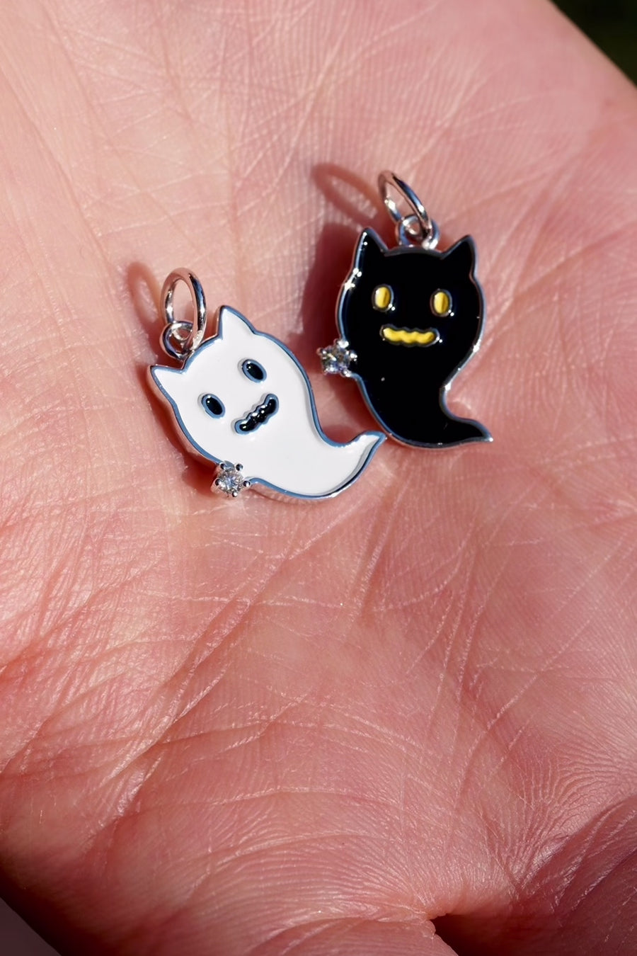 お守りゴーストキャットの商品動画。白猫・黒猫のチャームのサイズ感、金属と天然ダイヤモンドの輝き、ネックレスの着用例、コレクションの集合を紹介します。